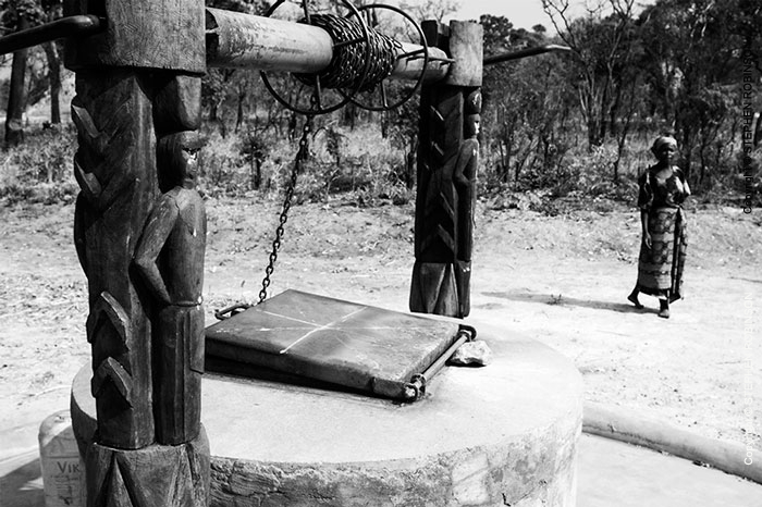 029_CZmA.8796BW-African-Carved-Water-Well-&-Village-Woman-NW-Zambia